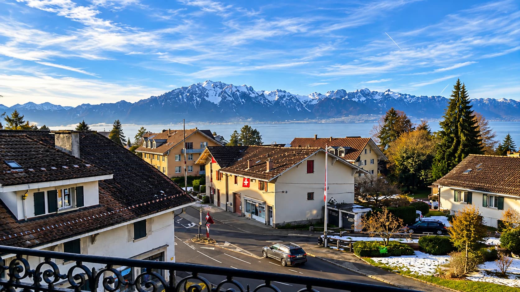 Le Léman et les Alpes vus d’un balcon de l’hôtel, au-dessus des toits de Blonay